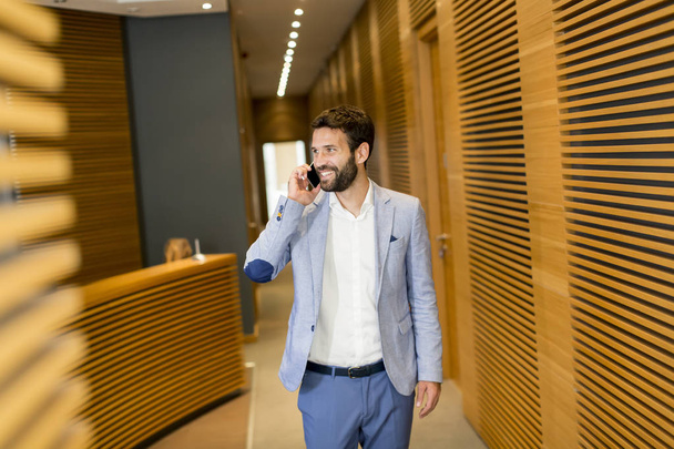 Modern businessman with phone in office - Photo, image