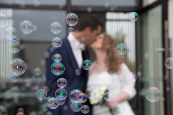 первый поцелуй для свадебной пары после празднования с мылом пузырьков
 - Фото, изображение