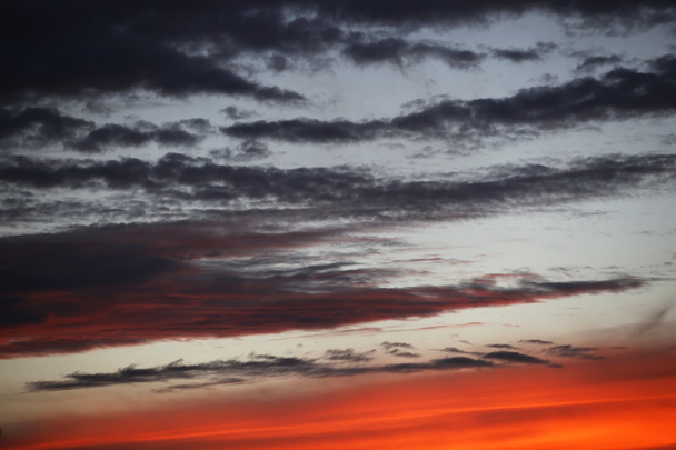 Прекрасний червоний захід сонця над італійським морем, багаті темні і світлі хмари
 - Фото, зображення