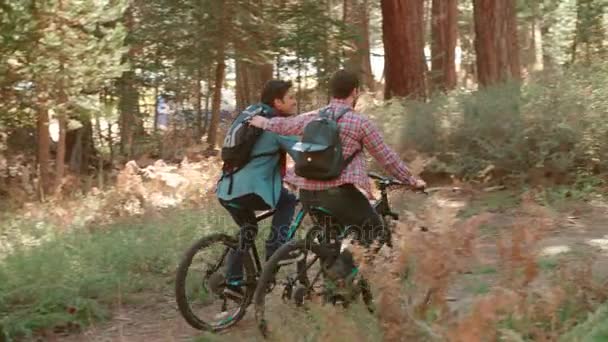 Male couple touch while cycling   - Video