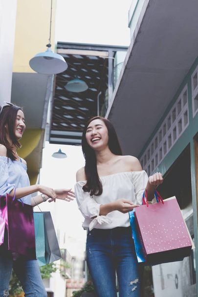 feliz asiático mujer con colorido compras bolsas en departamento stor
 - Foto, imagen