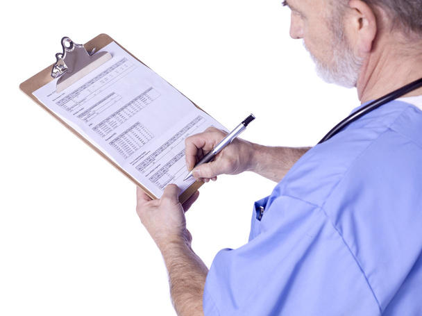 A male doctor with a medical clipboard writing - Photo, Image