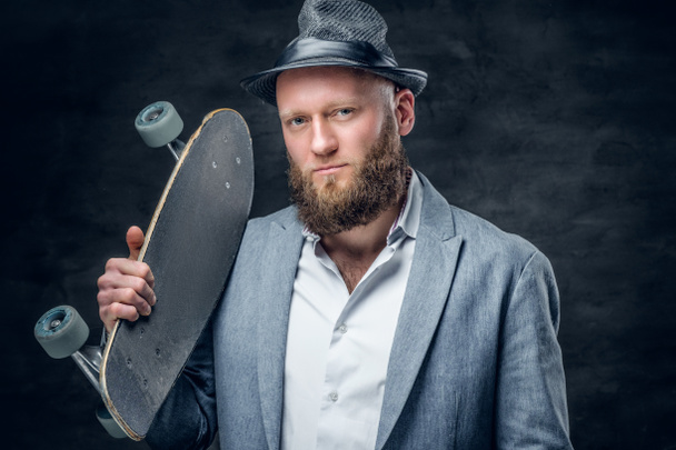 Homem que segura skate em um ombro
 - Foto, Imagem