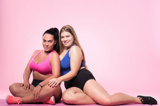 Two chubby women sitting on floor - Foto, immagini