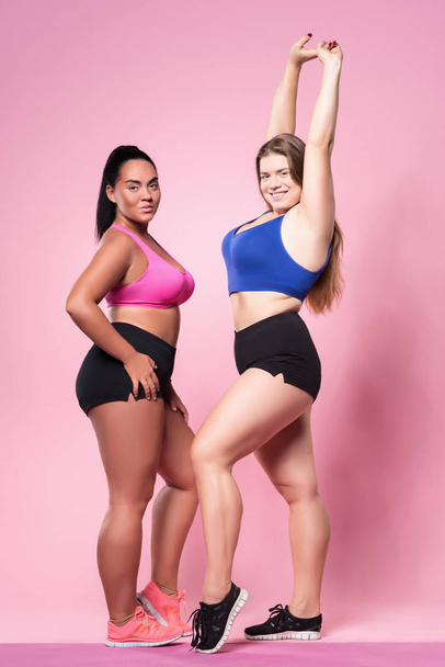 Par de mulheres com sobrepeso posando contra fundo rosa
 - Foto, Imagem