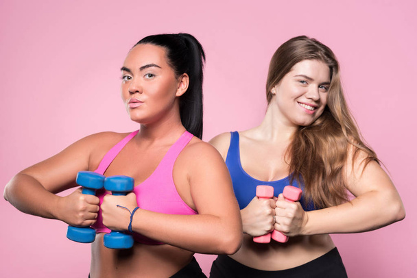 Two plump women exercising with dumbbells - 写真・画像