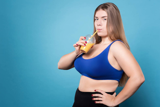 Young chubby lady drinking juice - Zdjęcie, obraz