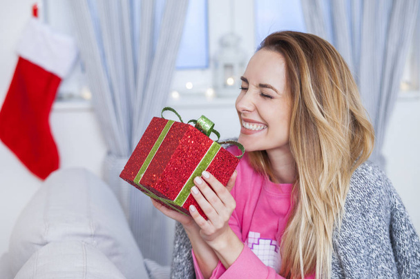 woman on the sofa holding a Christmas present - 写真・画像