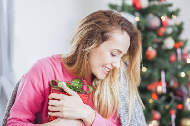 woman on the sofa holding a Christmas present - Photo, Image