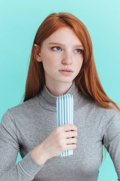 Portrait of serious redhead young woman holding pencils - Photo, Image