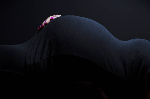 Pregnant womans body shape with hand at belly - Photo, Image