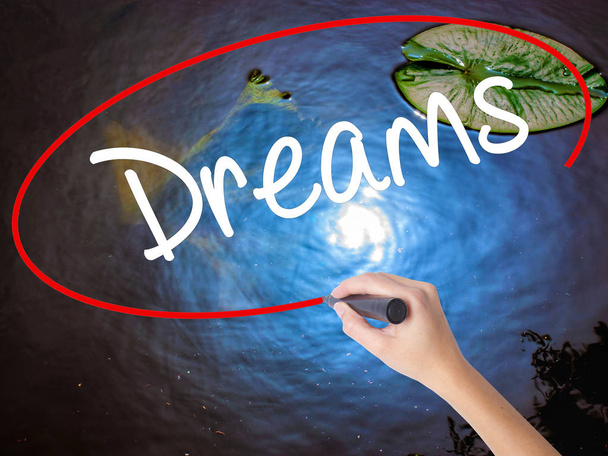 Frau schreibt Träume mit Filzstift über transparente Tafel - Foto, Bild