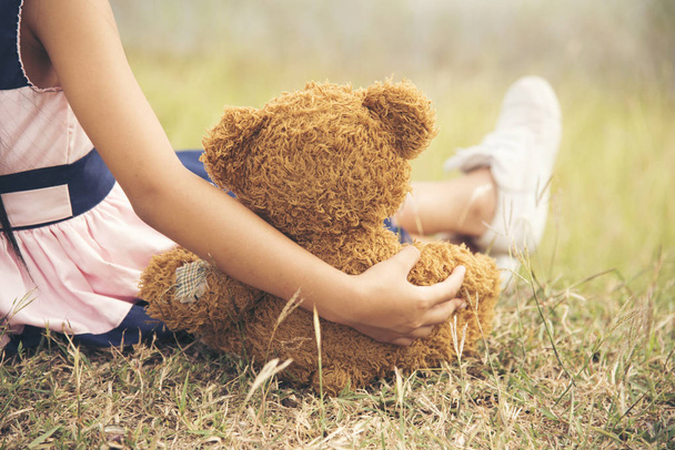 little girl hugging a fluffy teddy bear - Фото, зображення