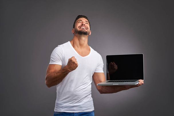 Young man with laptop - Foto, afbeelding