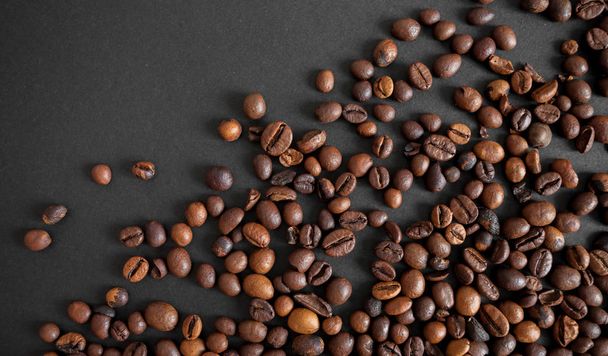 granos de café tostados sobre fondo de papel negro
 - Foto, imagen