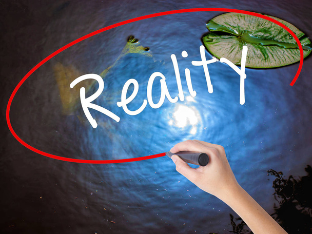 Woman Hand Writing  Reality with marker over transparent board - Photo, Image