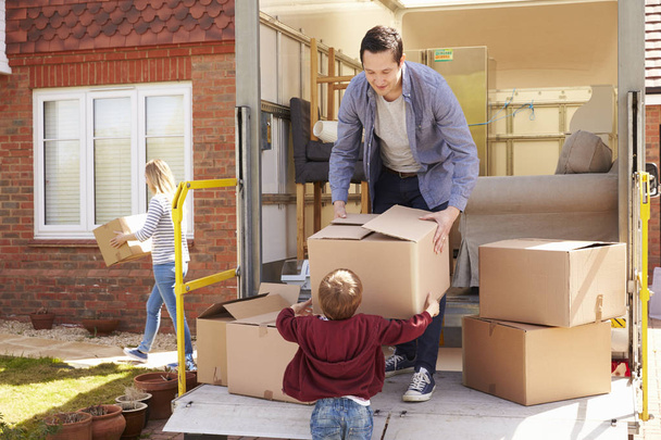 Family Moving Boxes From Removal Truck - 写真・画像