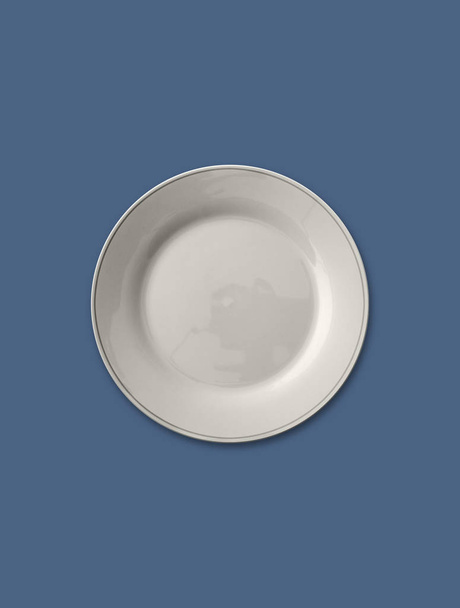Απομονωμένη άδειο πιάτο σε γκρι χρώμα με μπλε φόντο - Φωτογραφία, εικόνα