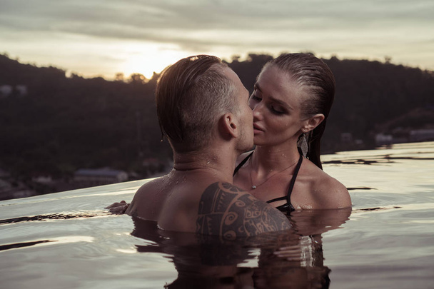 Romantic couple alone in infinity swimming pool - Photo, Image