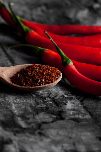 Lusikka mausteita chili ja tuoretta chiliä grunge tumma tausta
 - Valokuva, kuva