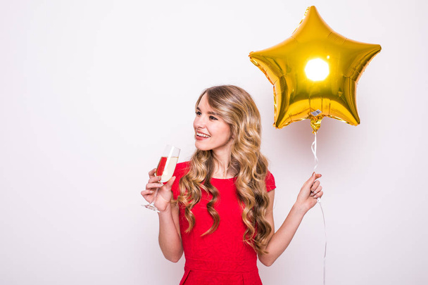 Nainen, jolla on kultainen tähti muotoinen ilmapallo hymyilee ja juo samppanjaa valkoisella taustalla
 - Valokuva, kuva