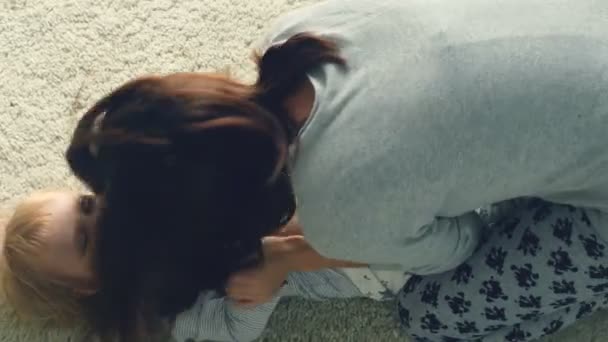 Молода мати грає з дочкою на підлозі
 - Кадри, відео
