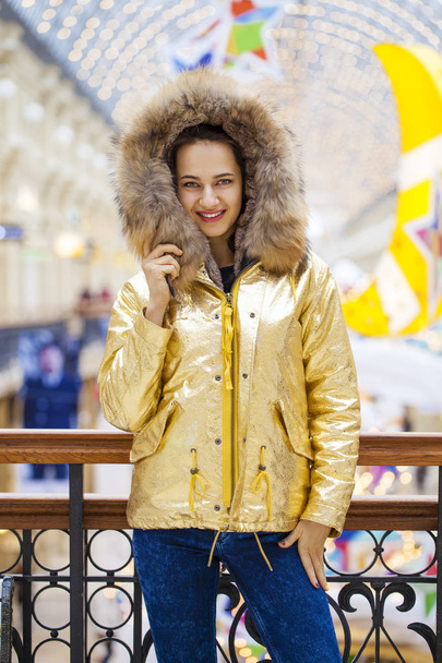 Beautiful brunette woman in golden fur coat - Foto, imagen