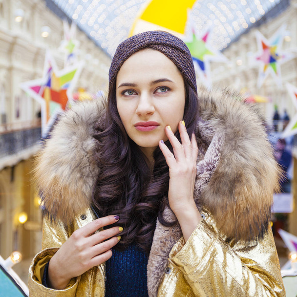 Beautiful brunette woman in golden fur coat - Fotoğraf, Görsel