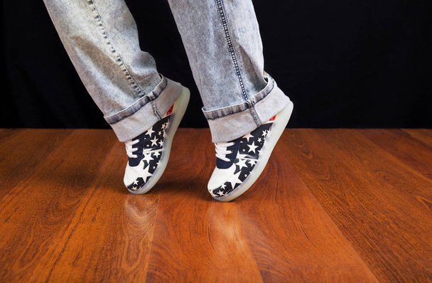 Woman jeans and sneaker shoes on wooden floor - Foto, Bild