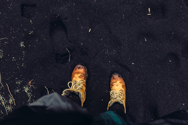 Legs in boots on seashore - Foto, afbeelding