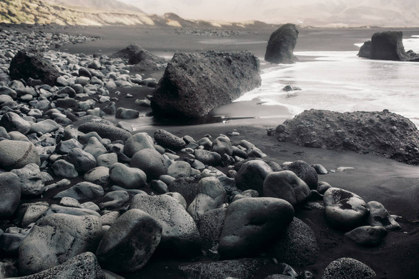 Seashore with black sand and stones - Photo, image