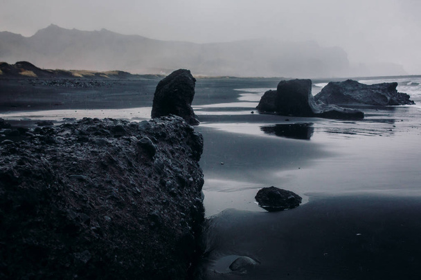 Seashore with black sand and stones - Foto, afbeelding