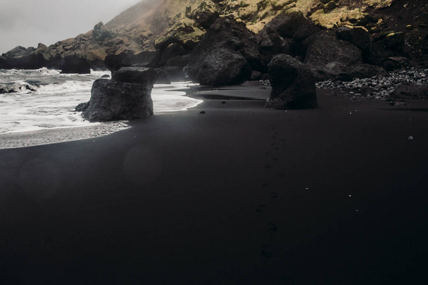 Seashore with black sand and stones - Foto, Bild