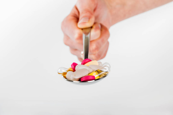 Купка таблеток у ложці на білому тлі
 - Фото, зображення