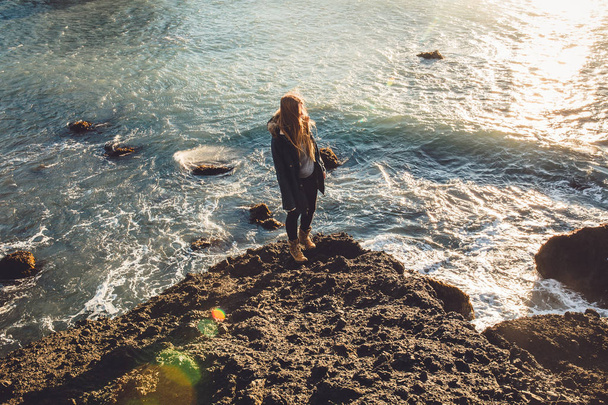 Girl standing on seashore stone - Photo, Image