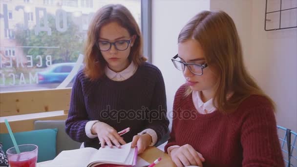 Estudiantes universitarias estudian en la cafetería dos amigas aprendiendo juntas
 - Imágenes, Vídeo