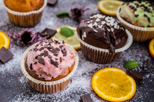Cupcakes met fruit en poedersuiker op een donkere achtergrond. Bovenaanzicht. Close-up - Foto, afbeelding