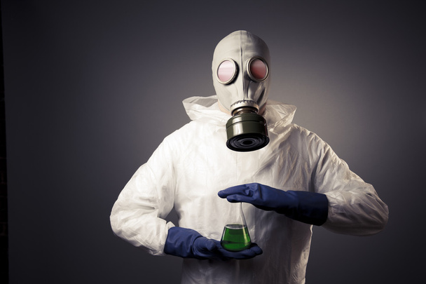 Homme avec un masque à gaz tenant un liquide radioactif
 - Photo, image