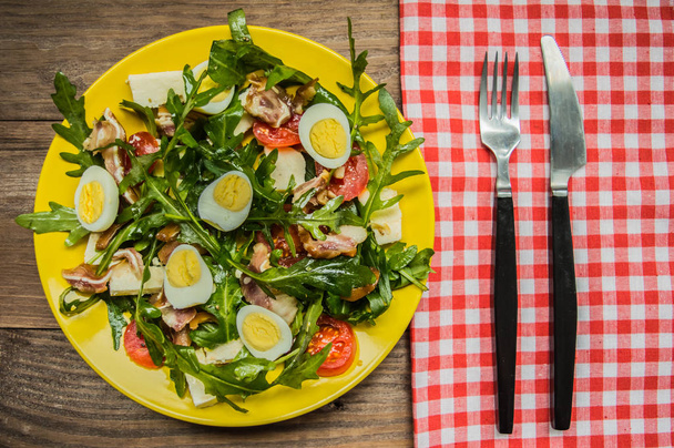 Warm salad with bacon and arugula. Wooden rustic background. top view - Photo, Image