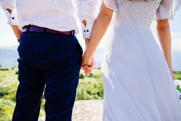 bride and groom holding hands together - Фото, изображение