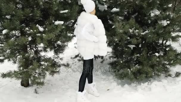 Vysoký model představuje v bílých šatech v Zelený strom v zimě. - Záběry, video