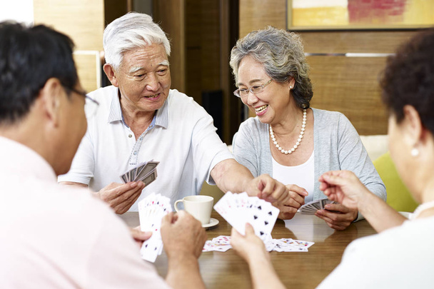 vanhempi aasialainen ihmiset pelaavat korttia
 - Valokuva, kuva