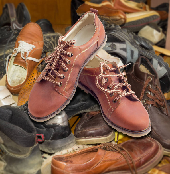 Uudet miesten kengät kasaan vanhoja erilaisia kuluneet jalkineet
 - Valokuva, kuva