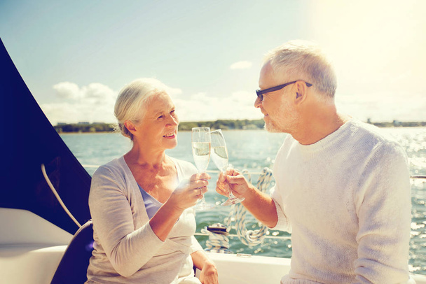 senior couple clinking glasses on boat or yacht - Фото, изображение