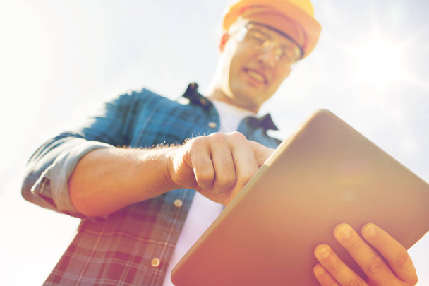 close up of builder in hardhat with tablet pc - Foto, afbeelding