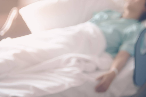 Blur ασθενή του ύπνου στο κρεβάτι με το φως του ήλιου από το παράθυρο στο νοσοκομείο αφηρημένα φόντο. - Φωτογραφία, εικόνα