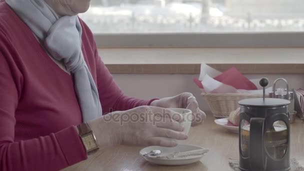Pensioner brings the mug of tea to her lips, takes a sip - Séquence, vidéo