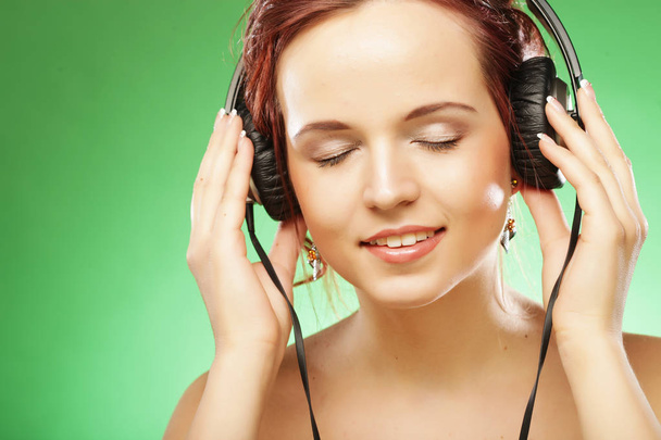 Young happy woman listening to music with headhones - Photo, Image