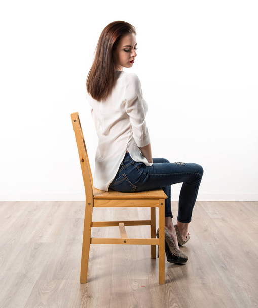 Young pretty model woman posing in studio on chair - Photo, Image