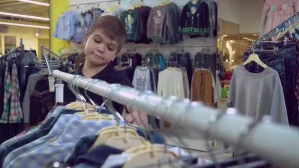Kid choose garment in the shop. - Footage, Video